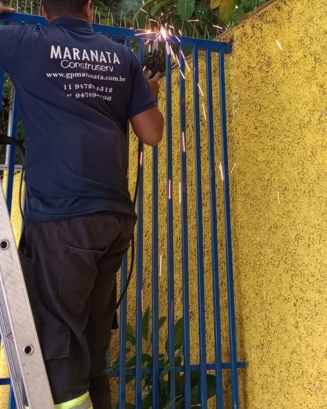 Montagem de portão de grade em obra residencial