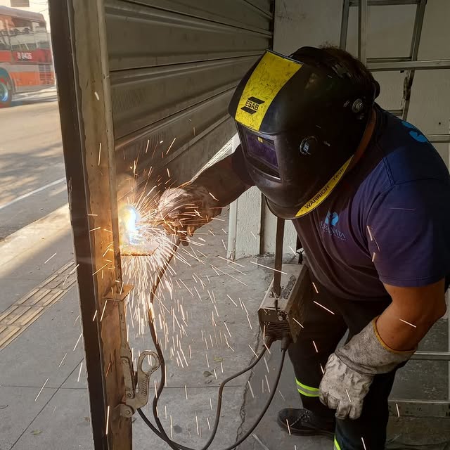 Técnico da Maranata soldando a estrutura de uma porta de aço